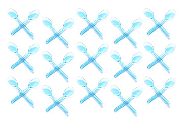 Pattern of isolated transparent plastic pastel blue crossed spoons. Say no to plastic concept. Flat lay, top view.