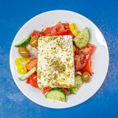 Greek salad plate with original feta cheese, olives, green pepper slices, tomatoes, onions and cucumber slices
