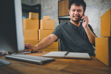 Online sales ideas for work at home. Asian man is answering  phone calls. To accept orders from online customers.Very good sale. online Business and E-commerce.Online shop Sell ​​products at home.