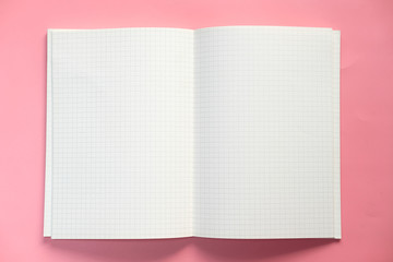 Top view of open notepad on pink background 
