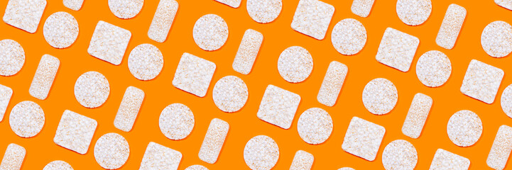 Pattern made of rice crackers or rice cakes on orange color background.
