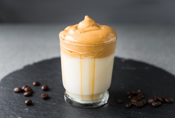 Dalgona coffee whipped cream mousse against grey background, also dubbed as quarantine drink