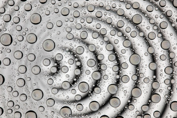 Concentric black and white lines through drops of water on glass