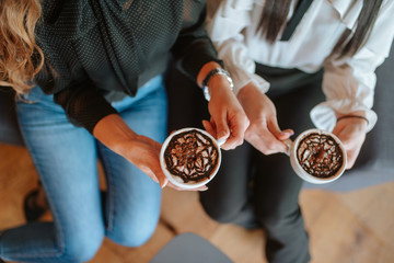 Close up of hands business women with cups of coffee