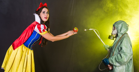 Woman wearing a fairy tale dress holding an apple with radiation symbol. Environmental problems...