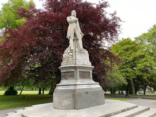 Statue of  "Samuel Lister" set against a large copper beech tree, in Lister Park, Bradford, Yorkshire, England