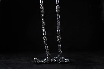 Silver chain hanging on a black background
