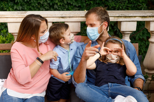 bellissima famiglia in posa nel proprio giardino con indosso la mascherina facciale per proteggersi