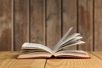 Open book on old wooden table.