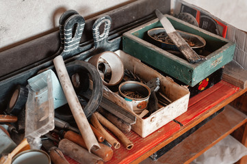 Fototapeta na wymiar Work tools lie on a chest of drawers during room repair. Spatula, pliers, chisels, knife