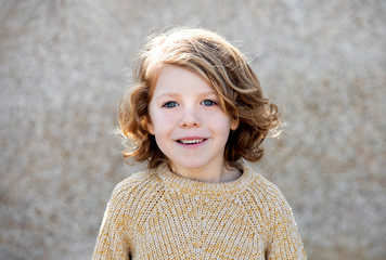 Happy blond child with long hair outside