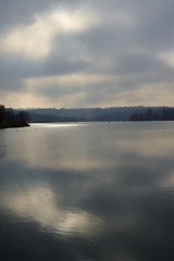 Landscape by the river. Mirror on the water. Water reflection. Boat near the water. The boatman in the fog. The rays of the sun on the water. Ukraine