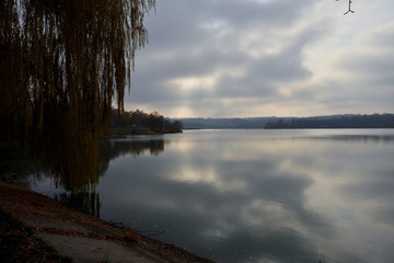 Landscape by the river. Mirror on the water. Water reflection. Boat near the water. The boatman in the fog. The rays of the sun on the water. Ukraine