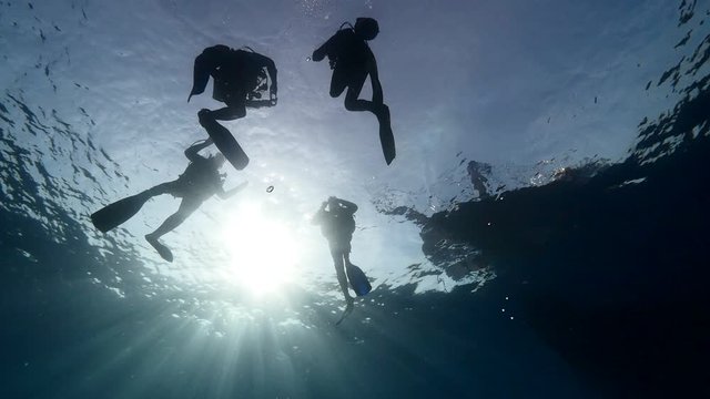 underwater scenery of scuba divers with boat end or begining of dive 