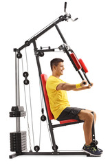 Fototapeta na wymiar Profile shot of a man exercising upper body on a fitness machine