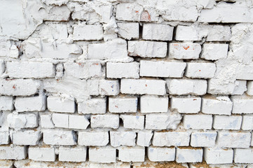 Beautiful white painted brick wall shabby old with cracks in the loft style with seams. Texture, background