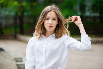 Portrait of a young blonde girl in white t-shirt and blue jeans