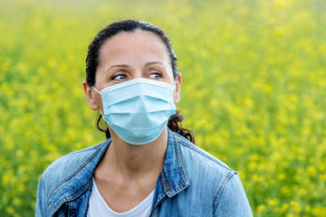 Brunette woman with a mask in the countryside