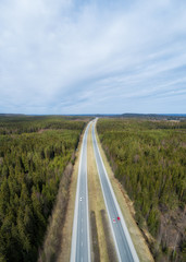 Aerial view of a highway going through the forest. Top view of motorway from high altitude. Trip And Travel Concept.