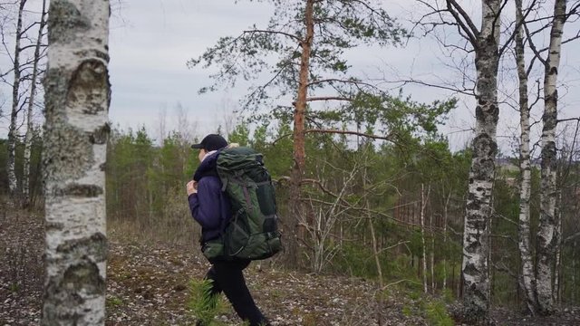 Girl traveler hiking with backpack. Slow motion footage. Trecking shot. Tracking slow motion footage of a girl hiking up a hill.