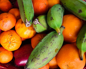 exotic fresh fruit green bananas and mandarins - top view