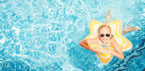 Pretty little girl in swimming pool, summer vacations.