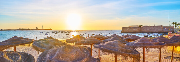Panorama of La Caleta beach with wicker sunshades, Cadiz, Spain