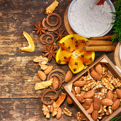 Christmas decoration with fir tree, oranges, cones, nuts, spices on a wooden table
