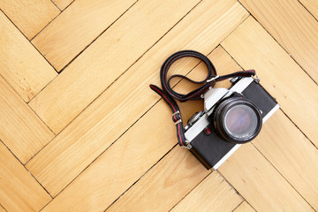 Old reflex camera on wooden parquet floor