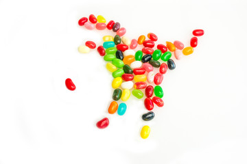A group of jellybeans in the shape of a scorpion closes in on a single jellybean. 