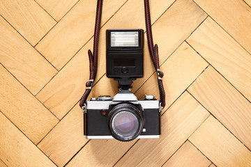 Old camera with flash lamp on wooden  floor - 350307912