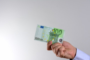 Hand holding and showing euro money or giving money. World money concept, 100 EURO banknotes EUR currency isolated. Concept of rich business people, saving or spending money.