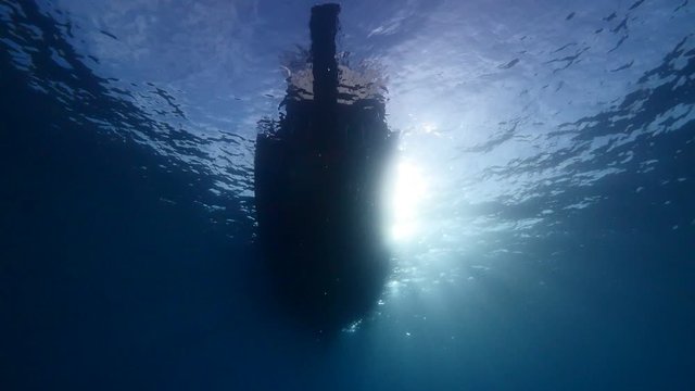 underwater scenery of scuba divers with boat end or begining of dive 