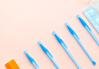 Flay lay school stationery supplies, medical masks, pen and hand gel sanitizer, school reopening, returning back to school after covid-19 coronavirus, post pandemic epidemic quarantine