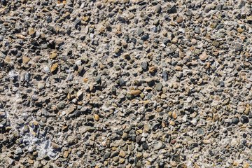 Concrete grey rock texture wall with small stones. Textural natural background. Copyspace.
