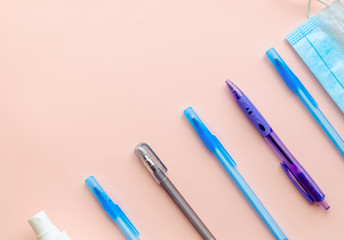 Flay lay school stationery supplies, medical masks, pen and hand gel sanitizer, school reopening, returning back to school after covid-19 coronavirus, post pandemic epidemic quarantine