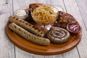 Meat plate with grilled sausages, ribs and chicken wings