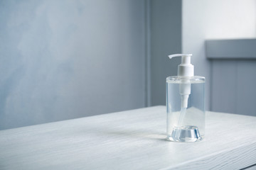 Dispenser bottle with antiseptic gel on table indoors. Space for text
