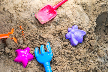 Fototapeta na wymiar Sandbox for children with forms and shovels of different colors
