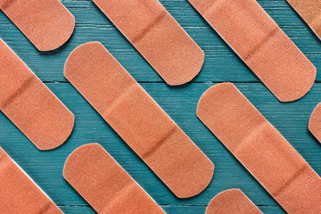 Rows of Adhesive Bandages on Turquoise Background