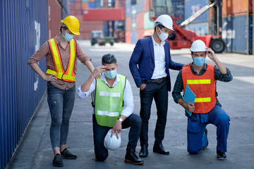 Group of technician or workers or engineer stay in cargo shipping container workplace and their look sad. Concept of lack good system and manager support for better industrial business.