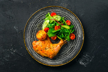 Baked chicken thigh served with fresh vegetables and grilled corn