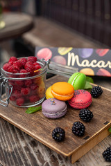 macaroons with berries on a wooden table