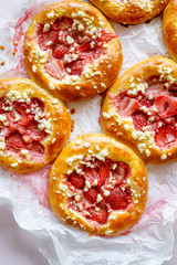 Yeast sweet rolls with the addition of strawberries and crumble, close up, top view. Traditional kolaches
