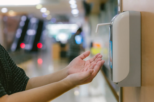 Hands under the automatic alcohol dispenser. Infection and hospitably concept. save and protect disease virus against germs and clean in the public area. 