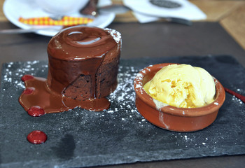 Chocolate fondant and vanilla ice cream in cafe. Delicious dessert in style. Sweet lifestyle.
