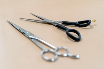 Professional hairdresser tools on brown background. Classic barber equipment - scissors