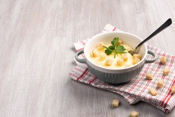 Cheese cream soup with croutons and parsley on gray marble stone table. Flat lay, top view and copy space for your text