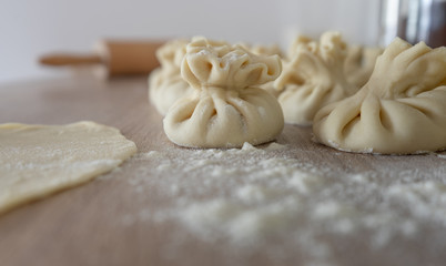 khinkali on a wooden board sprinkled with flour