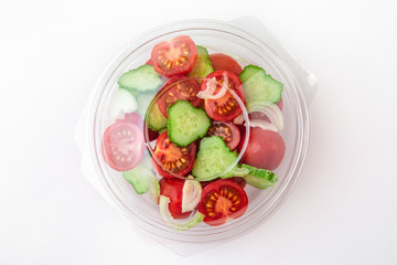Salad in plastic package for take away or food delivery isolated on a white background.